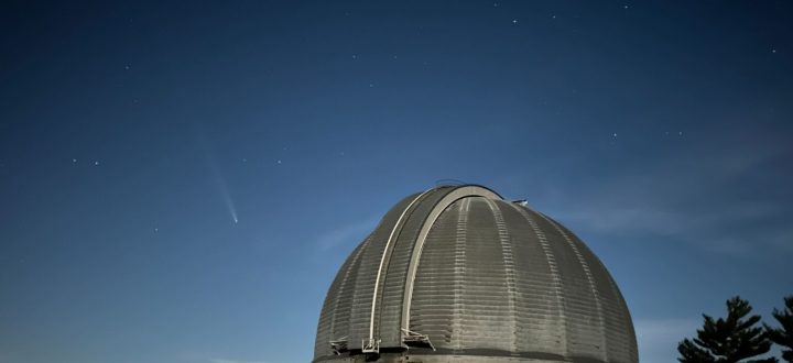 Yerkes Observatory dome at dusk with a comet visible in the night sky above Williams Bay, Wisconsin