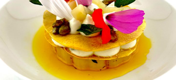 Layered squash tasting course at Opus near Lake Geneva, topped with edible flowers in a golden butter sauce